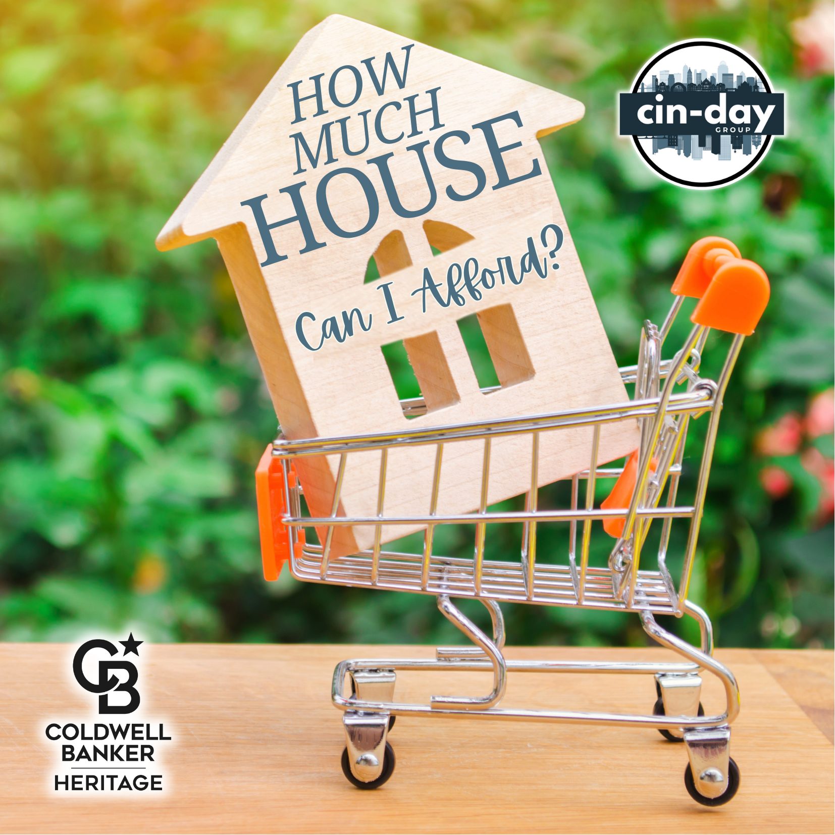 Wooden house with text ‘How Much House Can I Afford?’ sitting inside a shopping cart, symbolizing the home buying process and affordability in real estate. The image also has Cin-Day Group and Coldwell Banker Heritage branding.